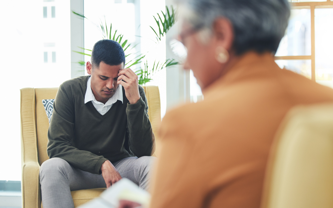 A male client discussing mental health goals during a talk therapy session with a Calgary psychologist.